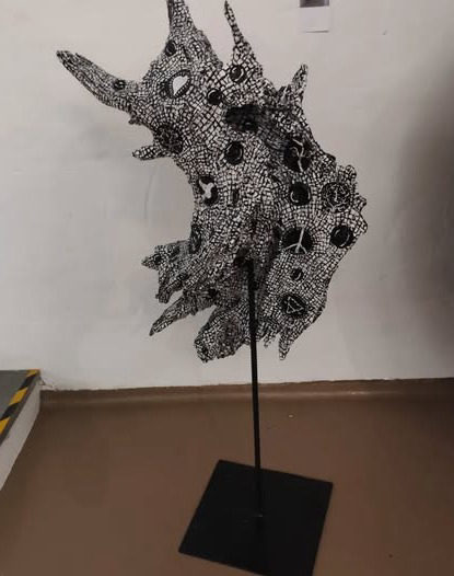 Escultura em raiz de eucalipto pintada a preto e branco, sobre haste e base